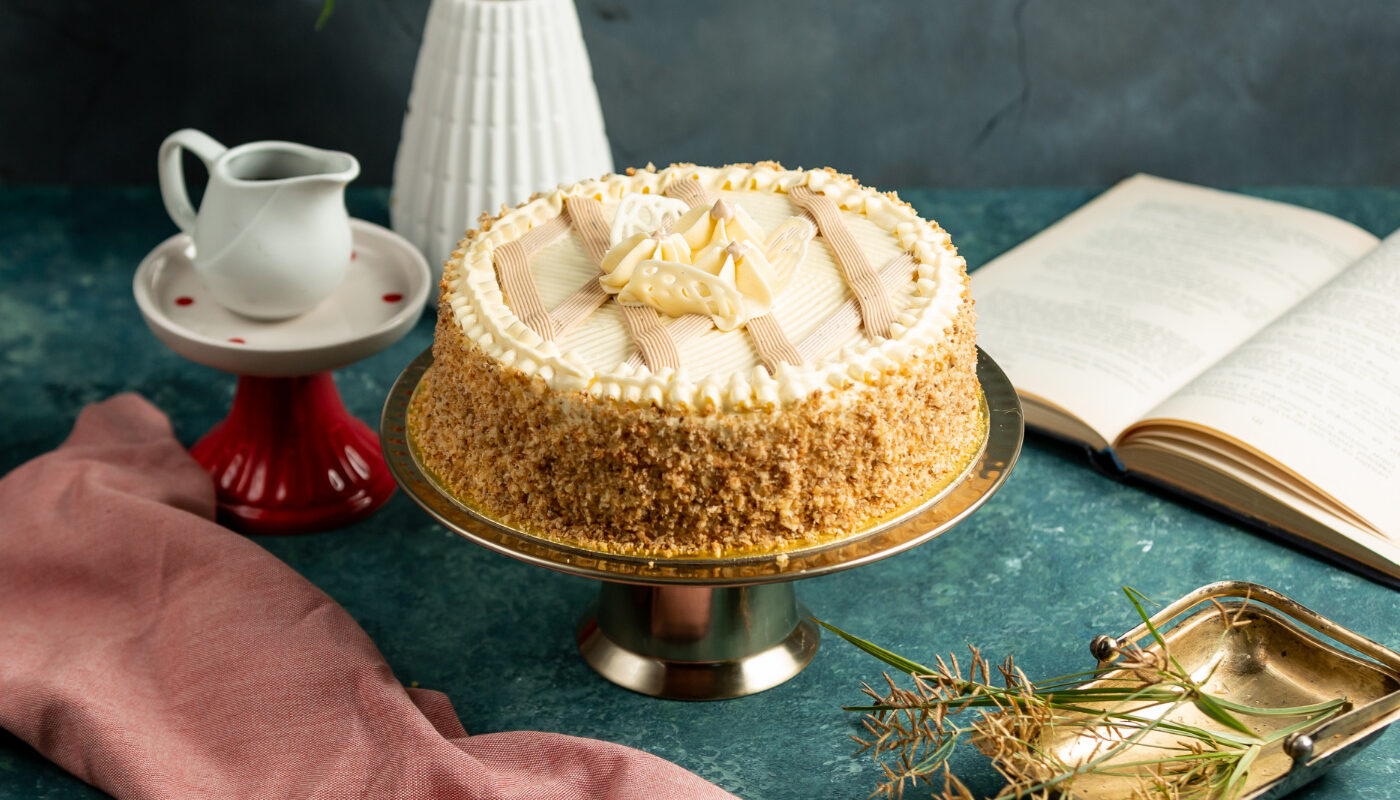 Торт "пчелиные соты" стоит на столе рядом со сливочником