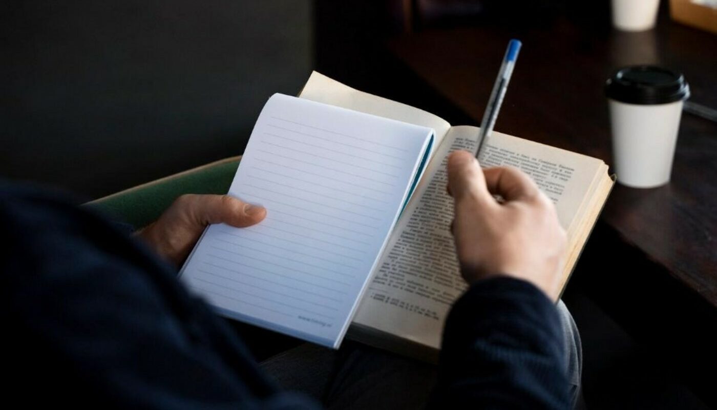 человек пишет в блокноте