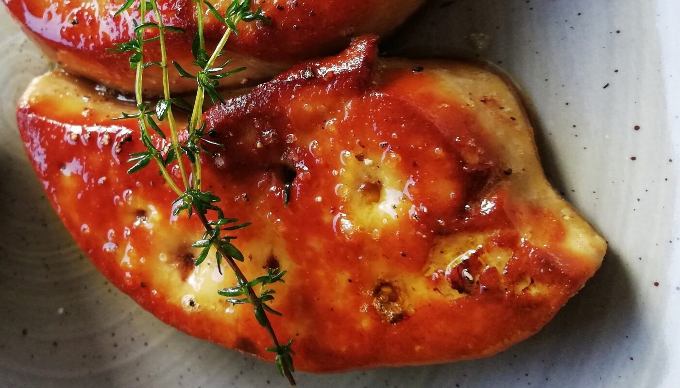 тушеная печень на блюде с веточкой розмарина