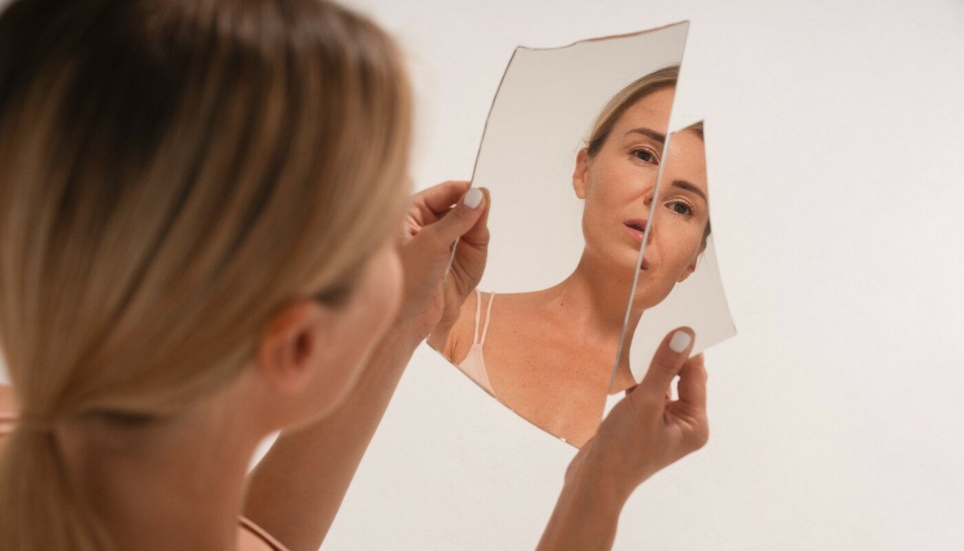 женщина смотрит в разбитое зеркало