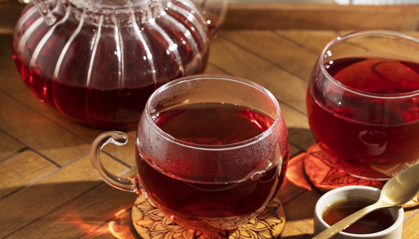 Чай в прозрачном чайнике и чашках на столе