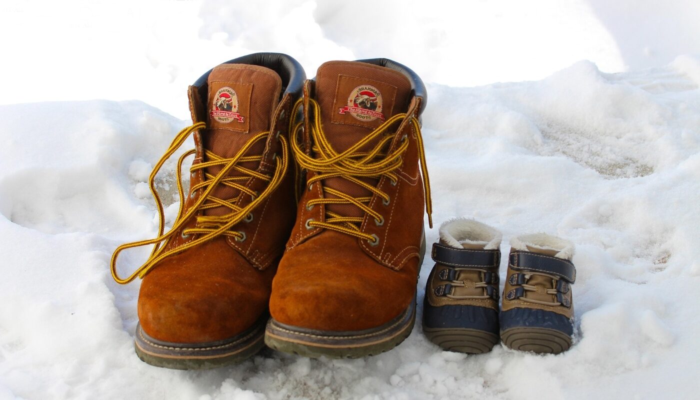 Обувь сапоги взрослые и детские ботинки стоят на снегу