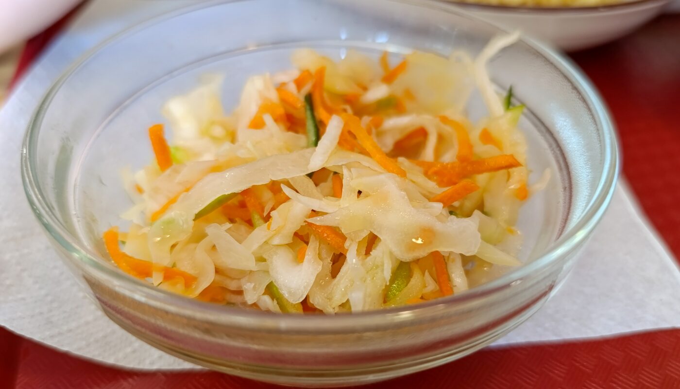 Хрустящая маринованная капуста в стеклянной миске на столе